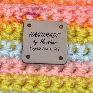 May include: Close-up of a handmade crochet item in a variety of colors, including orange, pink, yellow, and blue. A small, square tag reads "HANDMADE by Heather Virginia Beach, VA."