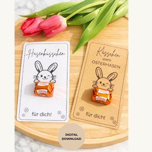 May include: Two Easter-themed cards with a cartoon bunny holding a chocolate candy. One card is white with the text "Hasenküsschen" and "für dich!", the other is brown with "Küsschen vom Osterhasen" and "für dich!". Pink tulips and green leaves are in the background.