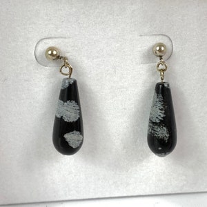 May include: A pair of black and white teardrop-shaped earrings with silver posts.