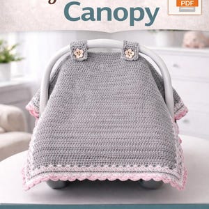 May include: A gray crocheted baby car seat canopy with a pink border and flower-shaped button accents. The text "Crochet Pattern PDF" and "Baby Car Seat Canopy" are displayed at the top. The canopy is designed to protect the baby and is an easy crochet pattern.