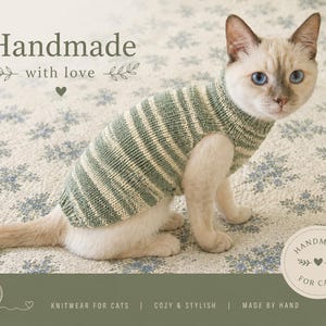 May include: A Siamese cat wearing a green and white striped knit sweater. The cat is sitting on a floral patterned surface. Text on the image reads "Handmade with love" and "Handmade for cats". The image also says "Knitwear for cats | Cozy & Stylish | Made by hand".