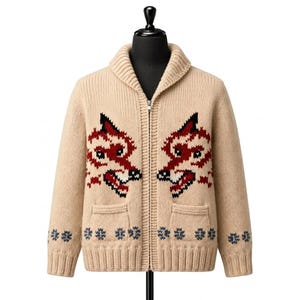May include: A beige knit zip-up cardigan featuring a shawl collar and two front pockets. The garment displays a prominent intarsia design of two wolf heads in red, black, and white on the chest, with small dark blue snowflake patterns near the hem.
