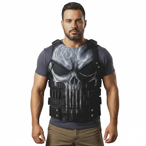 Op de afbeelding: Zwart tactisch vest met een groot schedelontwerp op de voorkant. De schedel is wit en grijs, met zwarte accenten. Het vest heeft verstelbare bandjes en meerdere zakken. Gedragen over een grijs t-shirt.