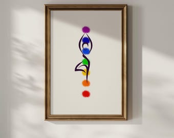 Op de afbeelding: Ingelijste kunstdruk met een gestileerde yogahouding met een reeks gekleurde stippen die chakra's voorstellen. Het kunstwerk bevindt zich in een houten lijst en hangt aan een witte muur.