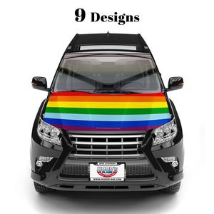 May include: A black SUV with a rainbow-striped hood cover. The hood cover features horizontal stripes in red, orange, yellow, green, blue, and purple. The text "9 Designs" is at the top. The license plate reads "Hood's Flags".