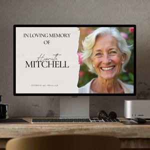 Könnte beinhalten: Ein Computermonitor zeigt eine Gedenkgrafik. Der Text lautet "In Loving Memory of Henrietta Mitchell" mit Daten. Ein Porträt einer lächelnden Frau befindet sich auf der rechten Seite. Der Monitor steht auf einem Holztisch mit Tastatur, Maus und Tannenzapfen.