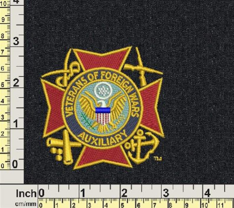 Op de afbeelding: Geborduurde patch met de tekst "Veterans of Foreign Wars Auxiliary" rond een centraal embleem. Het embleem bevat een adelaar, een schild en een blauwe streep. De patch is rood, goud, blauw en wit op een zwarte achtergrond.