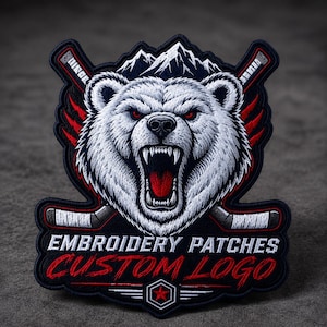 Peut inclure: Écusson brodé avec un ours blanc rugissant, des yeux rouges et une gueule ouverte, des crosses de hockey et un motif de montagne. Le texte indique "EMBROIDERY PATCHES CUSTOM LOGO" en rouge et blanc.