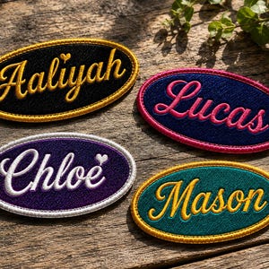 May include: Four oval-shaped embroidered patches featuring names in cursive script. One black patch with gold text 'Aaliyah', one navy blue with pink 'Lucas', one purple with white 'Chloe', and one teal with gold 'Mason'. Each has a matching border.