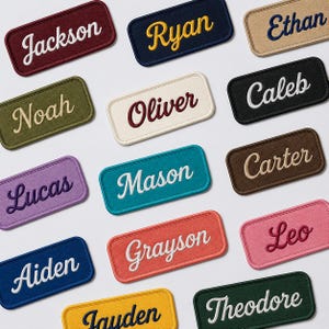 以下が含まれることがあります： Jackson、Ryan、Ethan、Noah、Oliver、Caleb、Lucas、Mason、Carter、Aiden、Grayson、Leo、Jayden、Theodoreといった名前が刺繍された、様々な色と筆記体フォントの長方形の布製ワッペンコレクション。