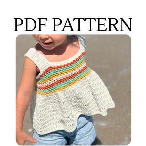 Könnte beinhalten: Ein cremefarbenes Häkeltop mit quadratischem Ausschnitt und einem farbenfrohen Streifendesign über der Brust. Das Top zeigt oben den Text "PDF PATTERN". Der untere Teil des Tops hat ein ausgestelltes, gerüschtes Design.