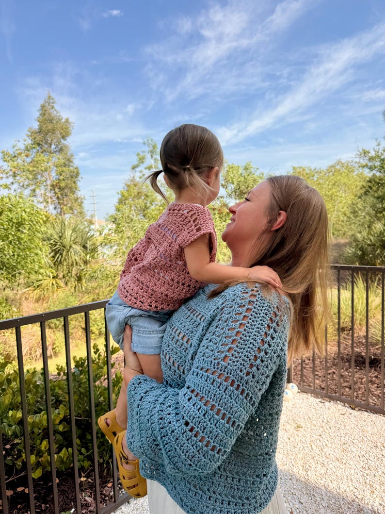May include: A dusty rose crochet top with short sleeves and a blue long-sleeved crochet jumper. The crochet garments feature a repeating openwork stitch pattern throughout the fabric, showcasing the intricate texture of the handmade yarn construction.