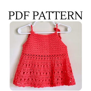 May include: A coral-colored crochet top featuring a solid stitch bodice and a decorative openwork skirt section. The garment is displayed on a white plastic hanger and includes the text PDF PATTERN printed in black above the image.