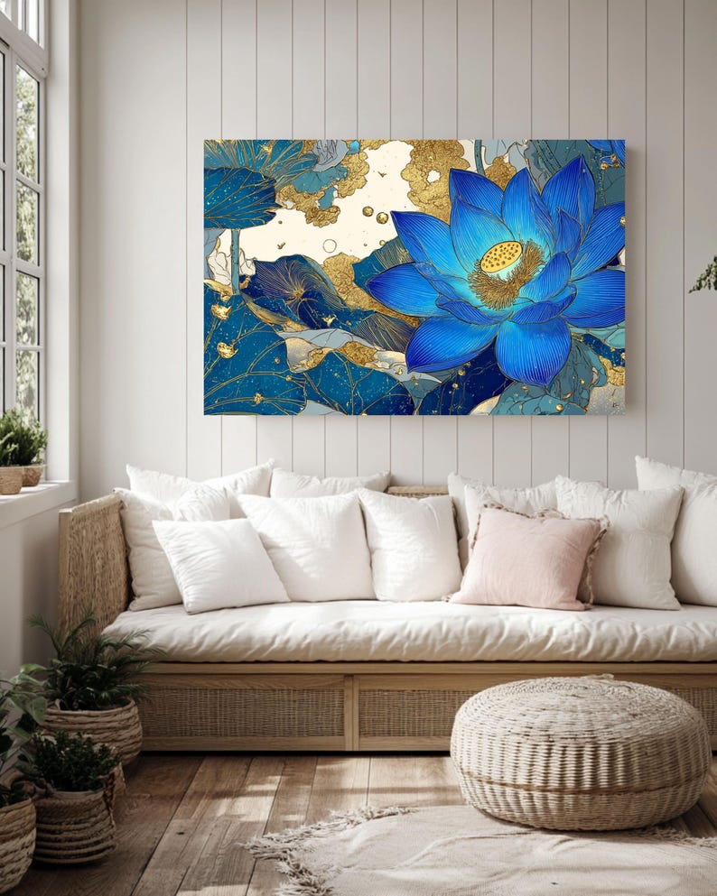 May include: A large canvas art print featuring a vibrant blue lotus flower with gold accents. The artwork is set against a backdrop of blue and gold foliage, creating a striking contrast. The floral art piece is displayed above a light-colored sofa with white pillows.