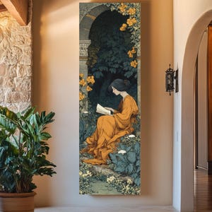 May include: A vertical rectangular wall art print depicting a person with dark hair wearing a long orange dress, sitting and reading a book within a stone archway surrounded by dark green foliage and clusters of small yellow and white flowers.