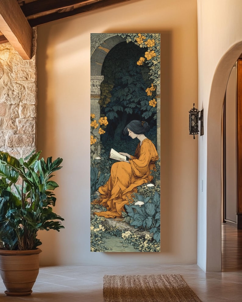May include: A vertical rectangular wall art print depicting a person with dark hair wearing a long orange dress, sitting and reading a book within a stone archway surrounded by dark green foliage and clusters of small yellow and white flowers.