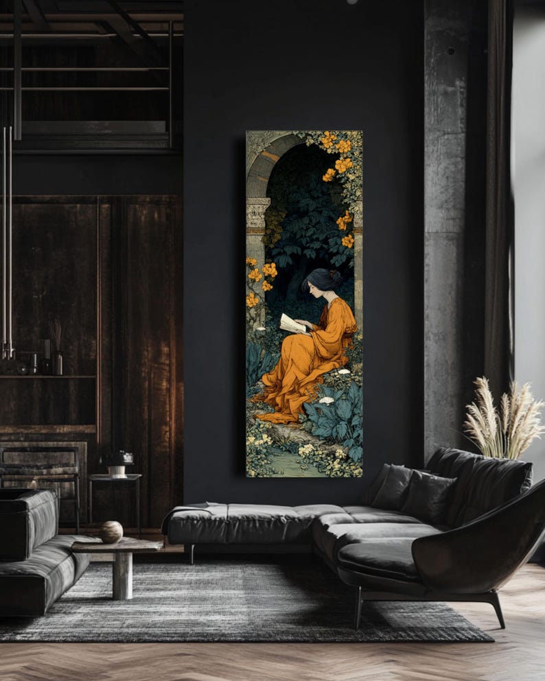 May include: A vertical rectangular wall art print featuring an illustration of a person with dark hair wearing a long orange robe, sitting and reading a book within a stone archway surrounded by dark green foliage and clusters of yellow flowers.