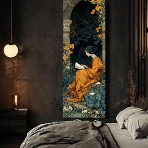 May include: A tall, rectangular wall art print featuring an illustration of a person with dark hair wearing a long, flowing orange dress, sitting and reading a book within a stone archway surrounded by dark green foliage and bright yellow flowers.