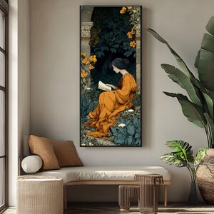 May include: A vertical framed wall art print featuring an illustration of a person with dark hair wearing a flowing orange robe, sitting in a garden setting while reading a book. The scene includes dark green foliage, stone architectural elements, and bright yellow flowers.