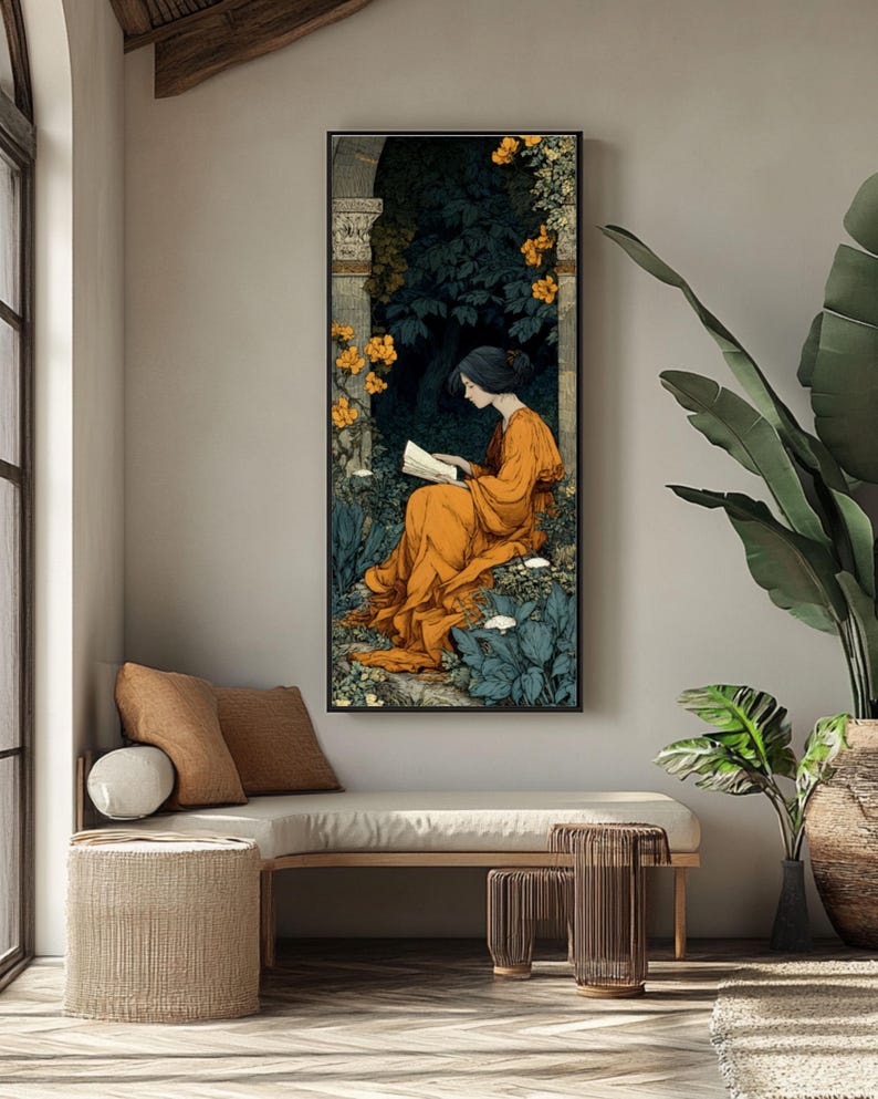 May include: A vertical framed wall art print featuring an illustration of a person with dark hair wearing a flowing orange robe, sitting in a garden setting while reading a book. The scene includes dark green foliage, stone architectural elements, and bright yellow flowers.