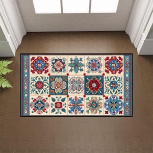 May include: Rectangular doormat with a repeating pattern of floral tile designs in red, blue, teal, and cream. The mat has a black border and a blue patterned edge, suitable for an entryway.