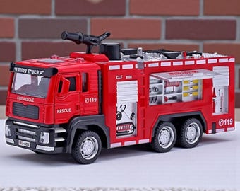 May include: A red toy fire truck with black and silver accents. The truck has the words "Alloy Truck", "Fire Rescue", and "Rescue" printed on it. The number "0119" is printed on the side of the truck.