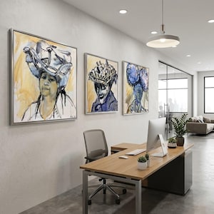 以下が含まれることがあります： 白い壁に飾られた3つの額入りの抽象的な肖像画。アートワークは、青、黄、白の色合いで帽子をかぶった人々の描写を特徴としています。オフィス環境には、机、椅子、コンピューターが含まれています。