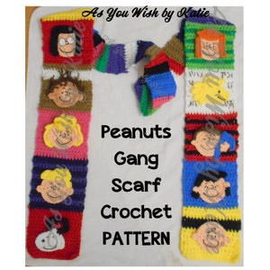 May include: A crochet pattern for a Peanuts Gang scarf. The pattern features characters from the Peanuts comic strip, including Charlie Brown, Lucy, Snoopy, and Linus. The scarf is made with colorful yarn and features a variety of stitches.