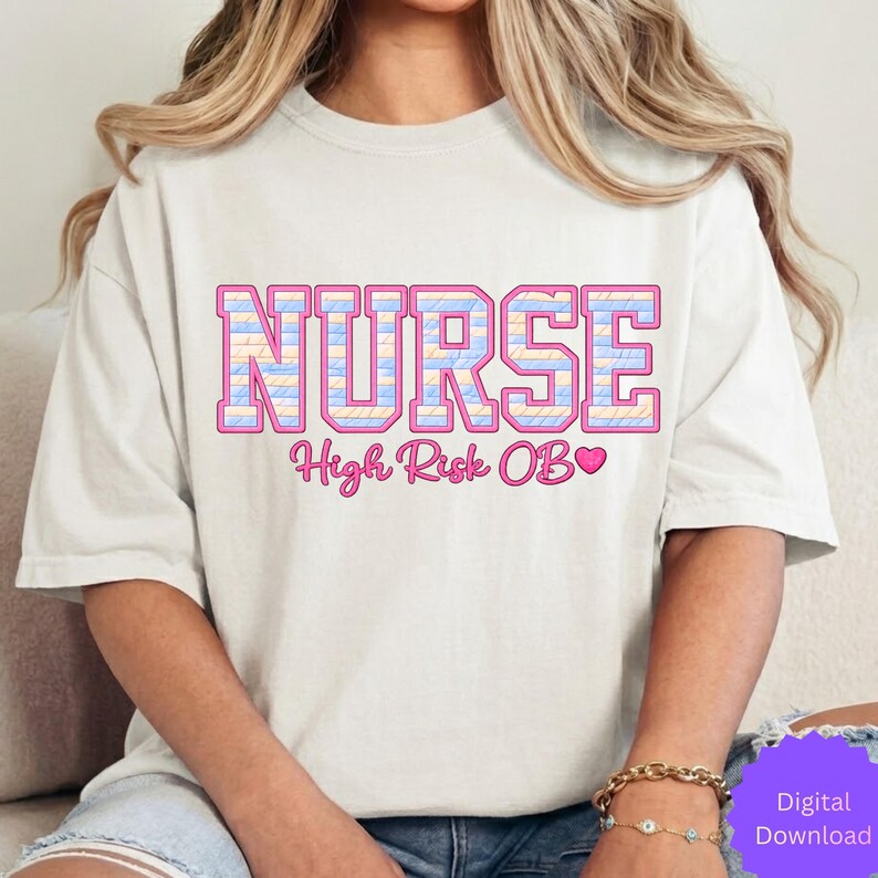 May include: A light-colored t-shirt with the word "NURSE" in a pink, blue, and yellow block letter design. Below the word "NURSE" is the text "High Risk OB" with a pink heart.