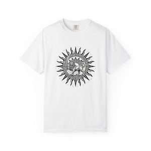 May include: A white short-sleeved t-shirt featuring a black graphic print on the chest. The design depicts a lion standing inside a circular frame, surrounded by a sunburst pattern with radiating rays. The lion is shown holding a sword.