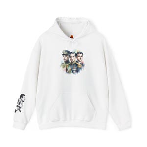Op de afbeelding: Witte hoodie met een aquarel illustratie van drie mannen in militaire uniformen op de voorkant. De linkermouw heeft een zwart-wit illustratie van drie mannen. De hoodie heeft een voorzak en een capuchon met trekkoord.