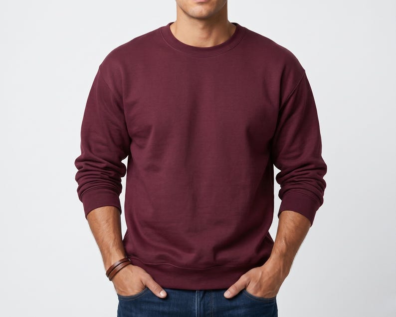 Puede incluir: Una sudadera de color granate liso con cuello redondo, mangas largas con pu&ntilde;os acanalados y dobladillo acanalado. La prenda presenta un dise&ntilde;o sencillo y liso con un escote redondeado, confeccionada en un tejido suave y opaco.