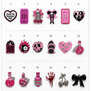 Pode incluir: Uma coleção de dezoito berloques de esmalte dispostos em três fileiras, intitulada Charm Options. Os designs incluem motivos rosa e pretos como caveiras, corações, frascos de poções, um bilhete, um laço, uma mão ensanguentada e cerejas.