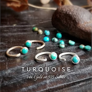 May include: Two pairs of turquoise gemstone rings, one pair in 14k gold and the other in 925 silver. The rings are open and have a simple design.