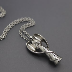 a necklace with a silver object on a chain