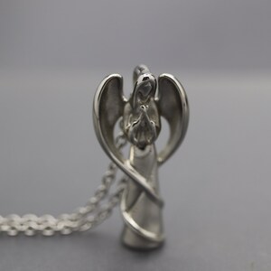 a silver angel figurine on a silver chain