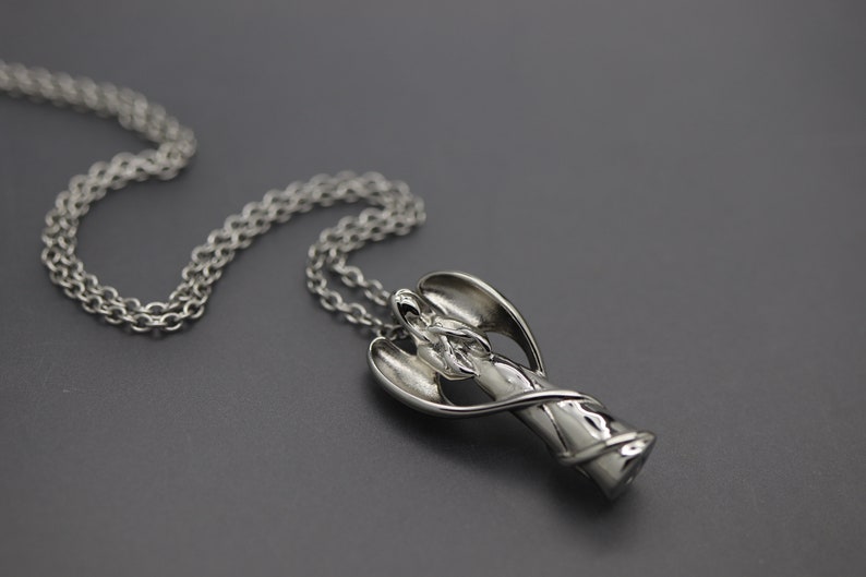 a silver necklace on a black surface