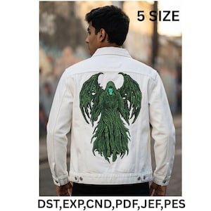 May include: A white denim jacket featuring a large green embroidered graphic of a hooded skeletal figure with wings on the back. The text 5 SIZE and DST, EXP, CND, PDF, JEF, PES are printed in black. The jacket has a collar, long sleeves, and buttons.