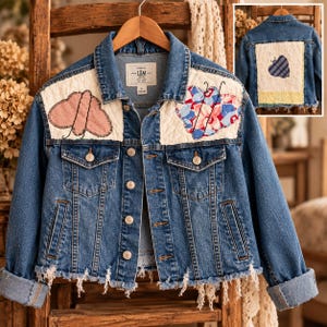 May include: A blue denim jacket featuring white quilted shoulder panels with embroidered butterfly designs. The jacket has a button-front closure, two chest pockets, and a frayed hemline. The back displays a large square patch with a butterfly.