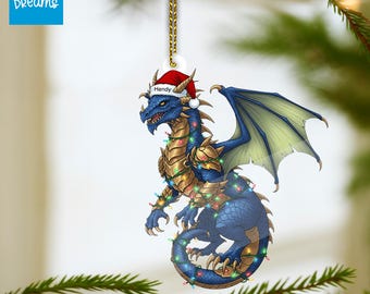 May include: A blue dragon ornament with a Santa hat and the name "Hendy". The dragon has gold armor, green wings, and is decorated with colorful Christmas lights. The ornament hangs from a gold chain.