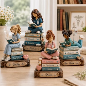 May include: Four nurse figurines sitting on stacks of books labeled with words like Healing, Strength, Empathy, Compassion, Care, Courage, Kindness, Dedication, Hope, Patience, Purpose, and Passion. Each base features a name: Emily, Sophia, Olivia, or Ava.