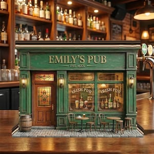 Könnte beinhalten: Miniaturmodell eines grünen irischen Pubs mit dem Text "Emily's Pub" und "Est. 19XX". Das Modell verfügt über eine Holztür, Fenster mit der Aufschrift "Irish Pub" sowie kleine Tische und Stühle. Links befindet sich ein Holzfass.