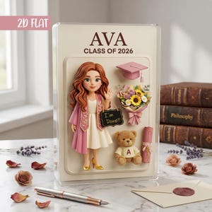 May include: A graduation-themed display featuring a figure of a graduate in a pink and white outfit, holding a sign that says "I'm Done!!". Includes a teddy bear, a bouquet of flowers, a graduation cap, and a diploma. The text "AVA CLASS OF 2026" is displayed at the top.