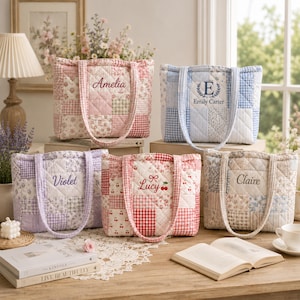 Könnte beinhalten: Fünf gesteppte Tragetaschen in verschiedenen pastellfarbenen Patchwork-Mustern, jeweils mit personalisierter Stickerei. Die Taschen zeigen Namen wie Amelia, Emily Carter, Violet, Lucy mit einem Kirschsymbol und Claire, alle mit passenden Vichy-Stoffhenkeln.