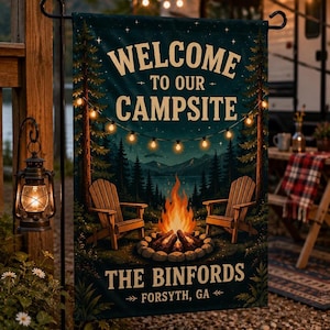 May include: A rectangular garden flag featuring a dark forest scene with a campfire, two wooden chairs, and string lights. The text reads "WELCOME TO OUR CAMPSITE" and "THE BINFORDS FORSYTH, GA" in cream-colored lettering against a dark background.