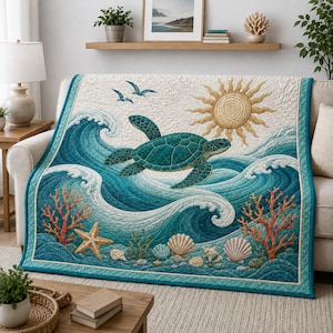 Könnte beinhalten: Eine gesteppte Tagesdecke mit einer Meeresschildkröte, die durch blaue Meereswellen schwimmt. Das Design zeigt eine goldene Sonne, zwei Vögel, orangefarbene Korallen, einen Seestern und verschiedene Muscheln auf cremefarbenem und blauem Grund.