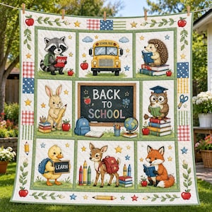 May include: A quilt featuring a central chalkboard with the text BACK TO SCHOOL, surrounded by panels of a yellow school bus and various animals including a raccoon, hedgehog, rabbit, owl, duck, deer, and fox, all with school supplies.