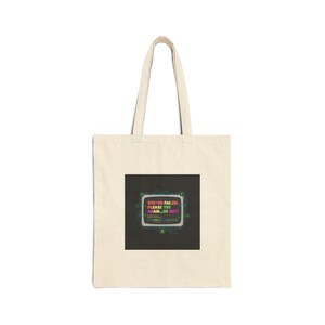 May include: Cream-colored tote bag with a black square graphic. The graphic displays a retro computer screen with the text "SYSTEM FAILED PLEASE TRY AGAIN...OR NOT!" in various colors. The bag has two long handles.