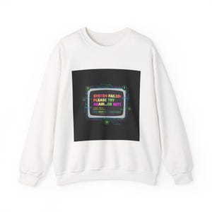 May include: White sweatshirt with a black square graphic. The graphic shows a retro computer screen with the text "SYSTEM FAILED: PLEASE TRY AGAIN...OR NOT!" in various colours. The design has a glitch effect.