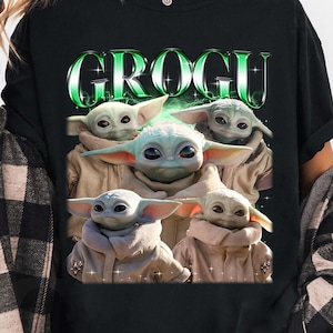 Może przedstawiać: Czarny t-shirt z zielonym napisem "GROGU" i grafiką Grogu w r&oacute;żnych pozach. T-shirt jest w stylu casual, odpowiednim do codziennego użytku. Projekt jest przyciągający wzrok i przedstawia popularną postać.